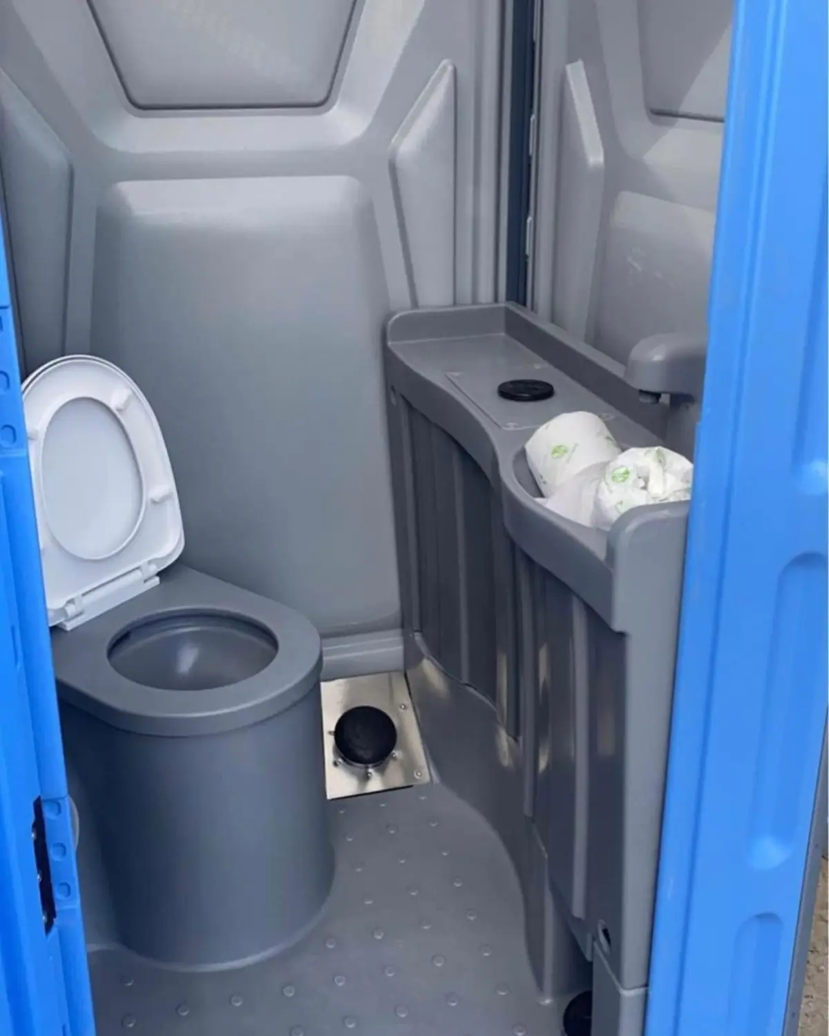 Inside a deluxe flushing portable toilet with a sink