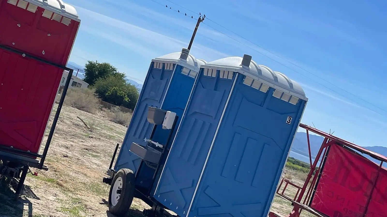 Trailer-mounted portable toilets ready for a field or road crew