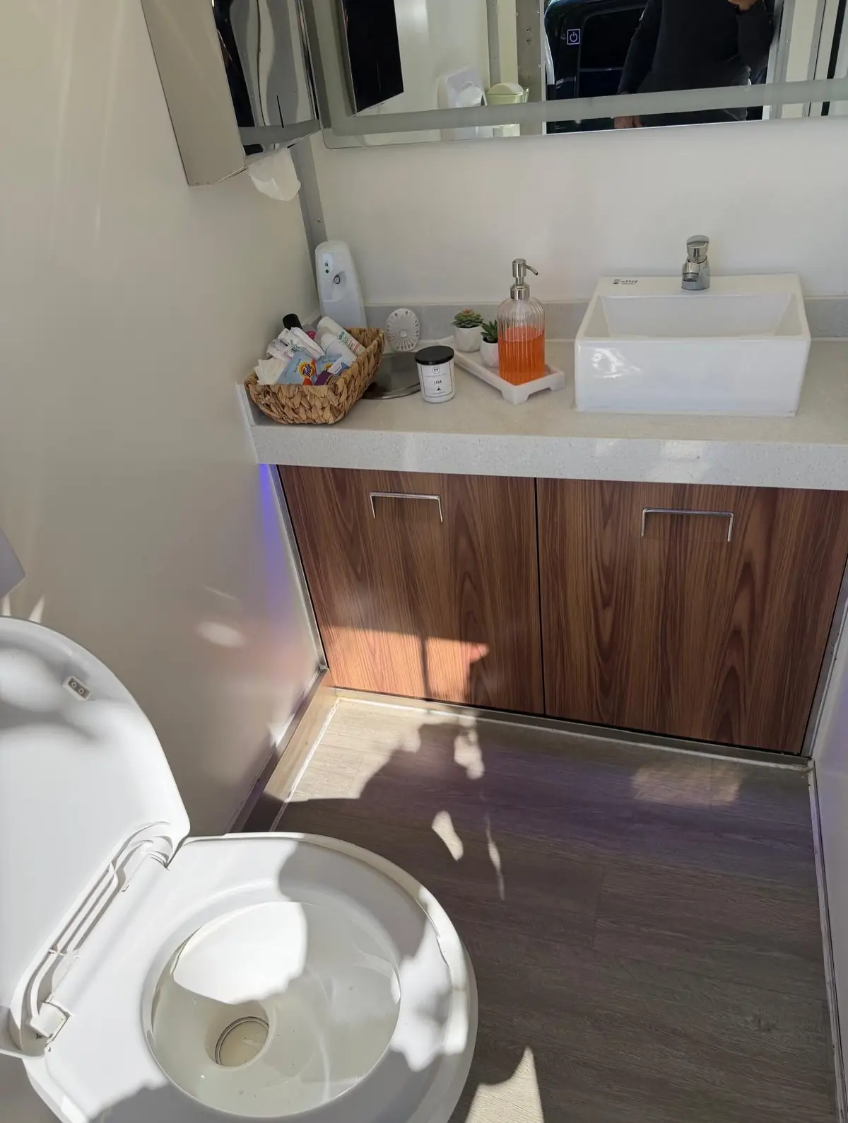 The vanity sink and mirror inside a restroom trailer.