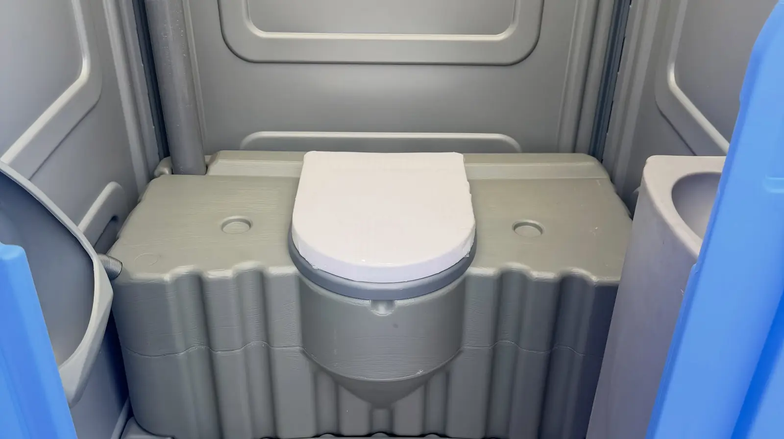 Roomy interior of a wheelchair-accessible portable toilet with a low seat